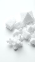 White sugar cubes and granulated sugar scattered on neutral background, suitable for food photography, culinary content, and sweetener product marketing.