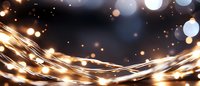 Glowing golden light trails with bokeh effect on dark background, creating magical atmosphere for festive designs and holiday celebrations.