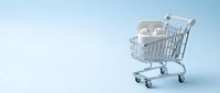 Wireless earbuds in shopping cart on blue background, representing online retail, e-commerce technology purchases and digital consumer goods.
