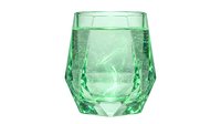 Transparent green glass tumbler filled with sparkling water and ice cubes, isolated on white background, ready for beverage, drink, and tableware design projects.
