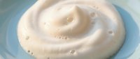 Creamy white cosmetic cream with smooth swirl texture in glass container, skincare moisturizer product for beauty and wellness applications.