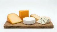 Assorted cheese varieties including cheddar, brie, and blue cheese displayed on rustic wooden board for food photography, culinary content, and gourmet cooking projects.