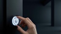 Male hand holding glowing circular tech interface with blue light against dark modern background, suitable for technology, innovation, and digital solutions concepts.