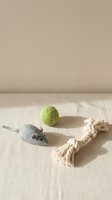 Cat toys set on linen surface: felt mouse, green wool ball, and cotton rope knot toy in natural minimalist style.