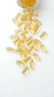 Golden omega-3 fish oil capsules spilling from white bottle on clean background for health and wellness supplement marketing materials.