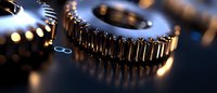 Close-up macro shot of metallic gear wheels with selective focus and bokeh light effects, showing industrial machinery parts in motion with golden reflections.