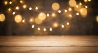 Warm bokeh lights create magical ambiance over rustic wooden table surface for holiday decorations, festive celebrations, and seasonal product displays.