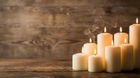 Lit candles arranged on rustic wooden surface with warm glow and smoke, suitable for wellness, spirituality, meditation, and home decor design projects.