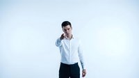 Young Caucasian businessman in white shirt pointing finger at camera with confident expression, isolated on light background.