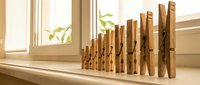 Row of wooden clothespins arranged on sunny windowsill creating natural home organization display with warm lighting and minimalist aesthetic.