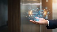 Digital transformation strategy concept with businessman hand holding glowing holographic network interface displaying connected icons and data analytics symbols in modern office environment.