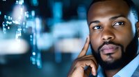 Young African American businessman talking on smartphone in modern office with city lights bokeh background at night for corporate communication concepts.