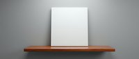 Blank white canvas on wooden shelf against gray wall for artwork display and interior design mockup presentations.