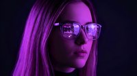 Young woman with long straight hair and eyeglasses wearing neon purple lighting against dark background, suitable for tech, cyberpunk, and modern digital design projects.
