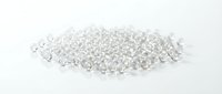 Clear glass beads scattered on white surface, suitable for jewelry making, crafts, decorative projects, and design applications.