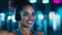 Young mixed race woman with bright smile wearingurred city lights at night, expressing joy and happiness.
