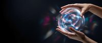 Hands holding glowing crystal ball with blue and pink light energy on dark background for fortune telling and mystical concepts.