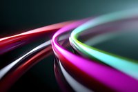 Colorful glowing light trails in motion creating dynamic curved lines against dark background, suitable for technology or communication concepts.