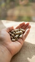 Hand holding dietary supplement capsules in palm, displaying wellness and health nutrition products for medical and pharmaceutical use.