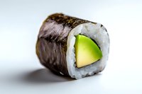 Fresh avocado sushi roll with nori seaweed and white rice on light background, macro food photography showing texture and ingredients detail.