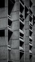 Brutalist concrete building facade with geometric patterns and repetitive angular balconies in monochrome architectural photography for modern design projects.