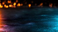 Dramatic dark background with glowing orange and blue bokeh lights creating mystical atmosphere on textured surface with shallow depth of field.