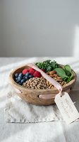 Wooden bowl filled with fresh berries, quinoa, almonds, kale and cucumber slices arranged for healthy eating and nutrition content.