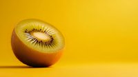 Fresh kiwi fruit half showing seeds and pulp on vibrant yellow background for healthy eating and nutrition concepts.