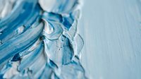 Blue and white acrylic paint strokes creating abstract texture on canvas surface. Artistic background for creative projects and modern design applications.