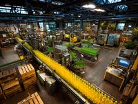 Modern beverage production facility with automated bottling line showing yellow bottles on conveyor belt in industrial manufacturing plant.
