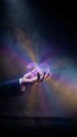Hand holding glowing neon infinity symbol against dramatic dark sky with colorful light rays and smoke effects, representing endless possibilities and limitless potential for business and growth concepts.