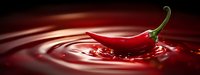 Red hot chili pepper splashing into liquid creating dynamic ripples and waves. Spicy food ingredient for culinary designs and cooking concepts.