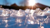 Sparkling ice crystals catching morning sunlight with bokeh effect and lens flare, close-up view of frozen water surface creating natural winter background.