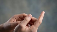 Open male hands reaching upward in prayer or meditation gesture against soft blurred background for spiritual wellness concepts.
