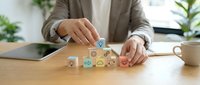 Person arranging wooden blocks with colorful emotion faces on desk, representing customer satisfaction, feedback rating, and service quality evaluation for business and marketing.