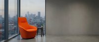 Modern orange armchair in minimalist high-rise apartment with floor-to-ceiling windows overlooking city skyline, empty concrete interior space for contemporary home design projects.
