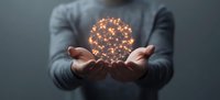 Glowing sphere of connected light dots floating between hands against dark background, symbolizing digital transformation and innovation in business.