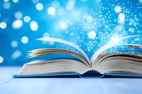 Open book with magical glowing pages and sparkling light effects against bright blue bokeh background, creating enchanting atmosphere for education and storytelling.
