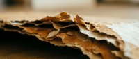 Weathered paper sheets with torn edges and aged texture creating rustic vintage background for creative projects and artistic designs.