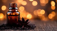 Amber essential oil bottle with star anise and seeds on wooden surface against warm bokeh lights background for aromatherapy and wellness concepts.