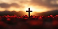 Christian cross silhouette against dramatic sunset sky with red poppies in foreground creating spiritual and remembrance atmosphere for religious designs.
