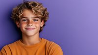 Happy young boy with curly blonde hair smiling warmly in orange shirt against vibrant purple background for youth lifestyle and education content.