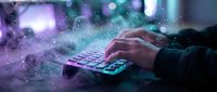 Hands typing on illuminated keyboard with glowing digital particles and bokeh lights creating futuristic technology atmosphere for business presentations.
