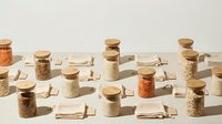 Zero waste kitchen storage with glass jars filled with grains, spices and organic ingredients on neutral background for sustainable cooking concepts.