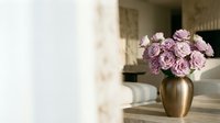 Purple carnations in golden vase on wooden table creating elegant home decor arrangement for interior design and floral styling projects.