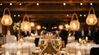 Champagne glasses toast at elegant wedding reception with string lights and rustic decor creating romantic atmosphere for celebration.