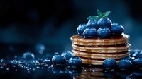 Stack of golden pancakes topped with fresh blueberries and mint leaf, drizzled with syrup on dark background for breakfast menu design.