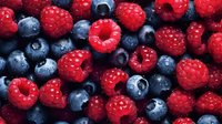 Fresh ripe raspberries and blueberries background, macro shot of mixed berries texture showing natural organic produce with vibrant colors.