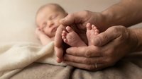 Newborn baby feet cradled in parent's hands, tender family bonding moment capturing love and care between generations, parenthood and new life.
