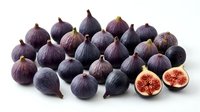 Fresh purple figs arranged on white background with cut halves showing red flesh. Organic Mediterranean fruit for healthy eating and cooking recipes.